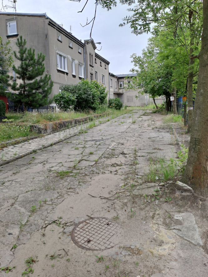 plac z budynkiem piętrowymw tle