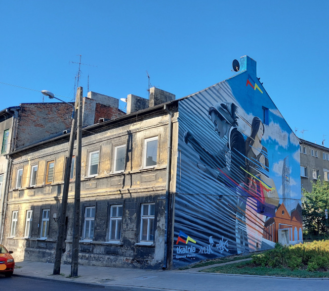 narożnik piętrowej kamienicy, z jednej strony be z okien, ściana pomalowana grafitti